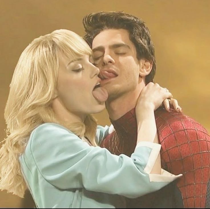 a man and woman kissing each other in front of a yellow background with spider - man on his chest