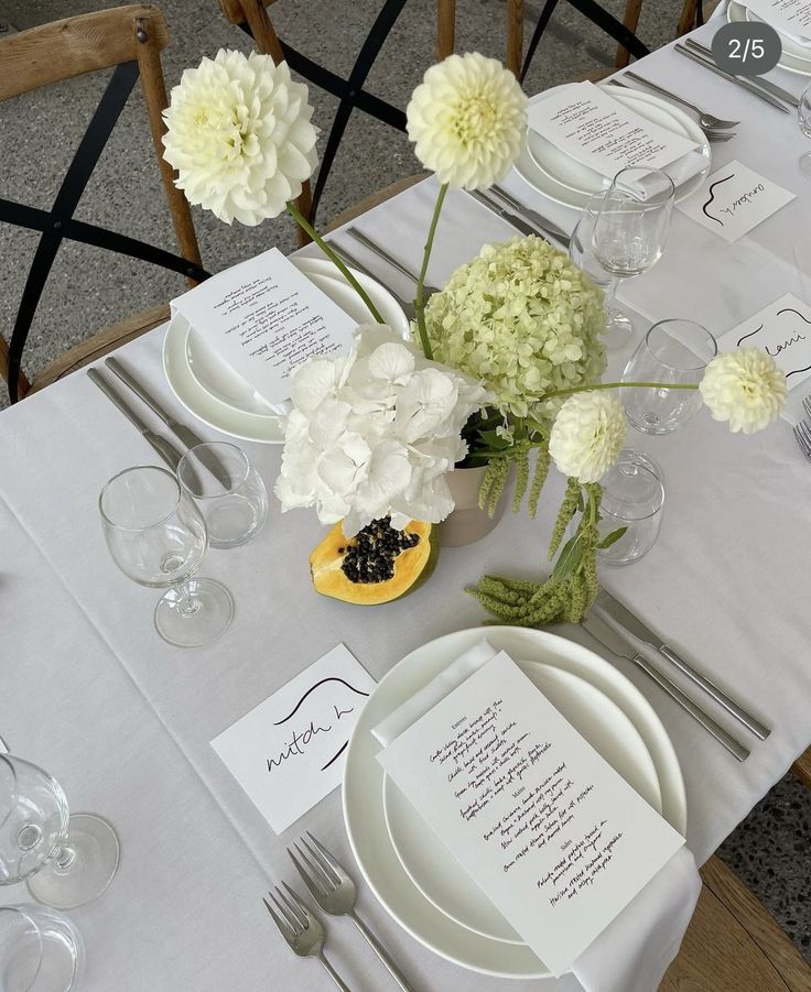 a table set with place settings and flowers