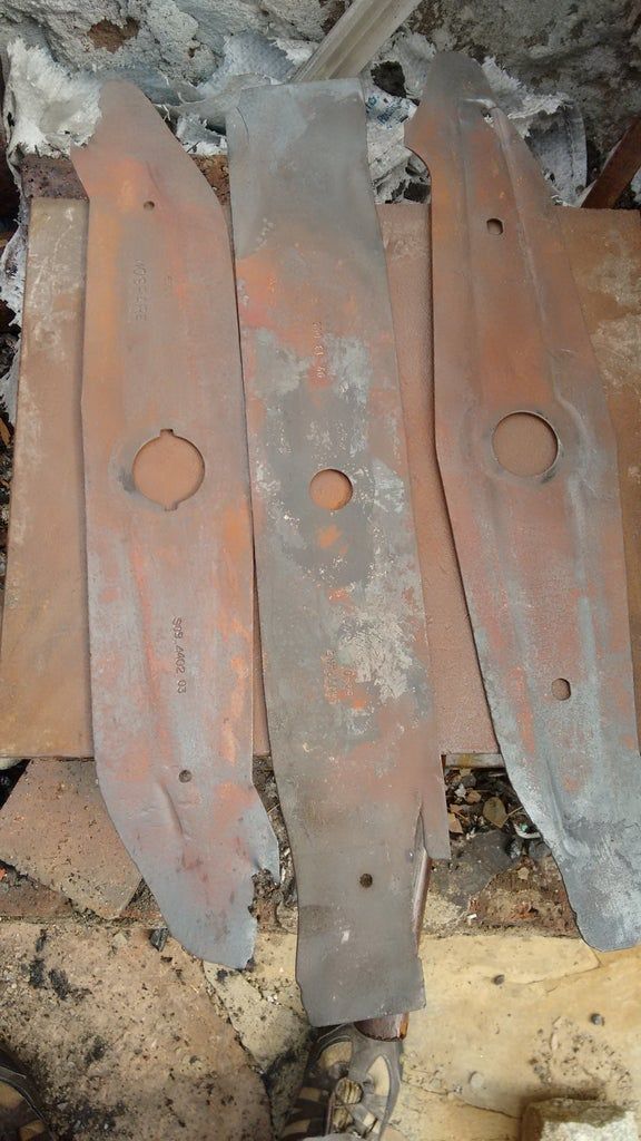 four pieces of metal sitting on top of a pile of rubble next to a brick wall