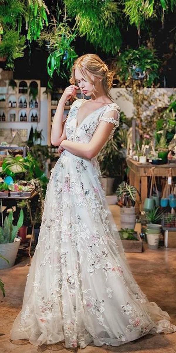 a woman in a white dress standing next to plants