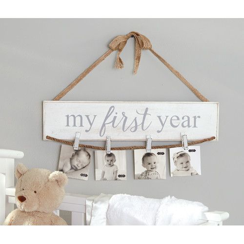 a baby crib with a teddy bear hanging from it's hooks and the words, my first year