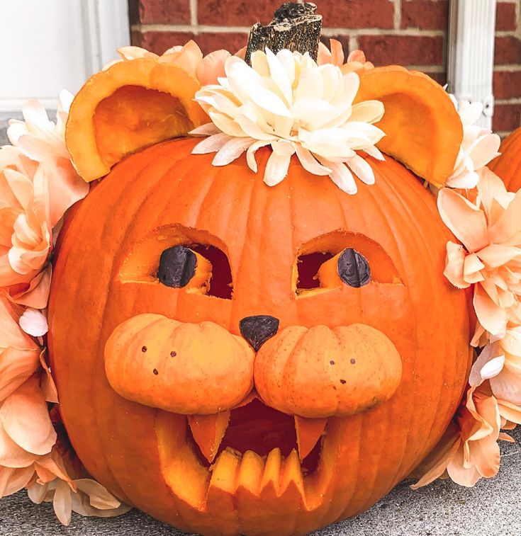 a pumpkin decorated with flowers and a cat's face