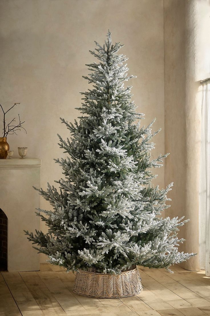 a white christmas tree in a basket on the floor