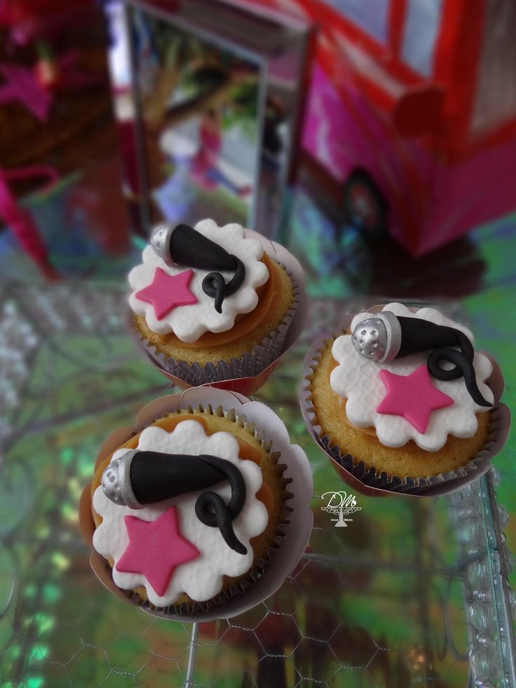 three decorated cupcakes sitting on top of a table