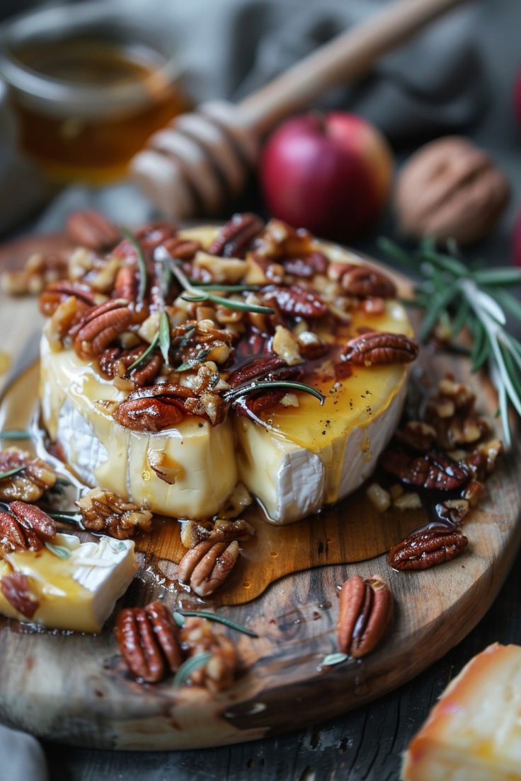 Baked brie topped with honey, pecans, walnuts, and rosemary on a wooden board. Onion Brie Appetizer, Brie Holiday Appetizer, Thanksgiving Recipes Brie, Baked Brie Honey Pecans, Honey Walnut Baked Brie, Thanksgiving Entree Ideas, Brie And Roasted Garlic, Baked Brie And Apples, French Baked Brie