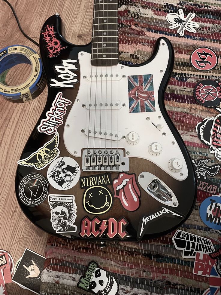 an electric guitar with stickers all over it