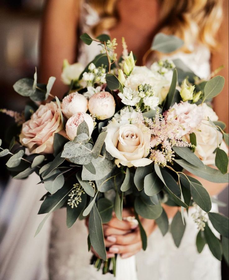 a woman holding a bouquet of flowers in her hands