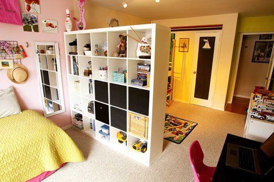 a bedroom with a bed, desk and bookcases in the middle of it