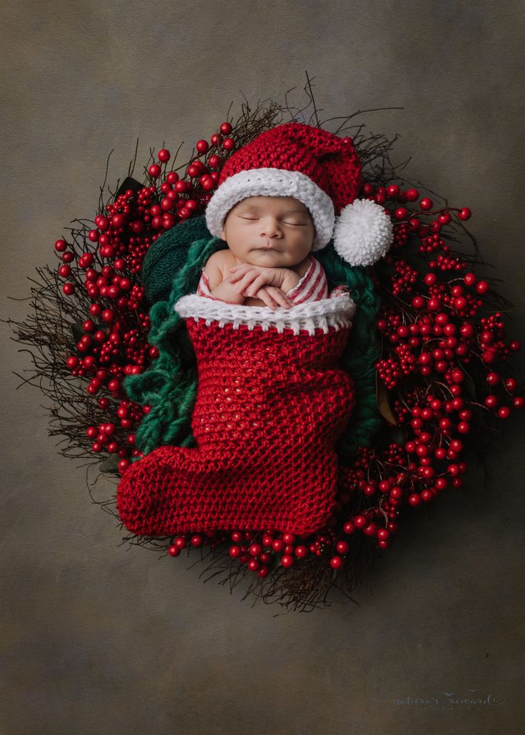 a newborn baby is wrapped in a christmas stocking