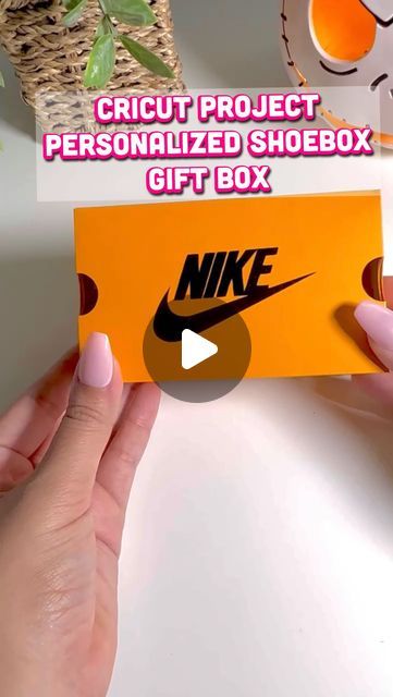 a person holding an orange box with a nike logo on it and the words, circuit project personalized shoebox gift box