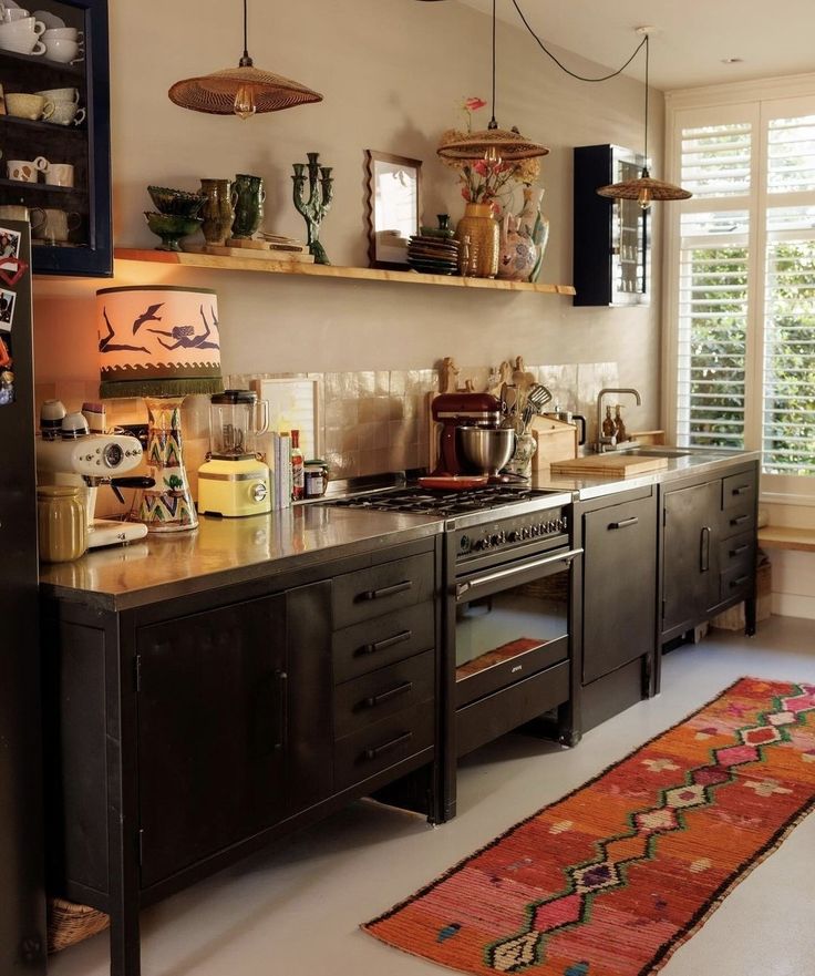 a kitchen with lots of counter space and hanging lights above the stove top, along with an area rug on the floor