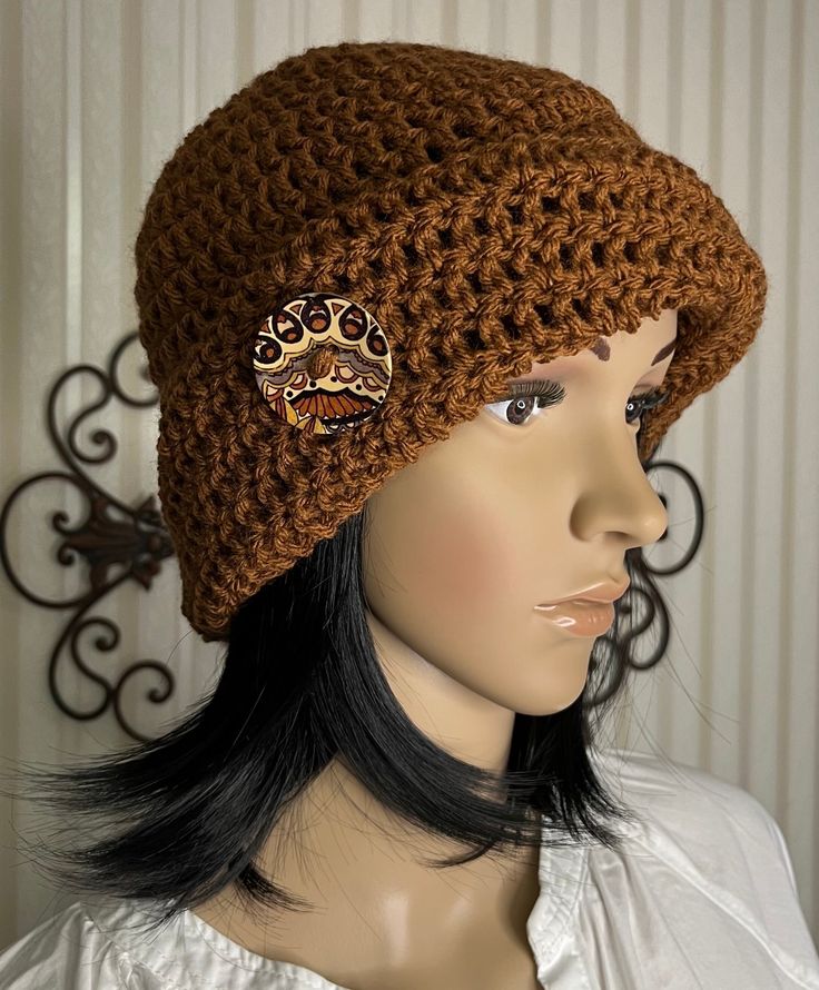 a mannequin head wearing a brown crochet hat with leopard patches on it