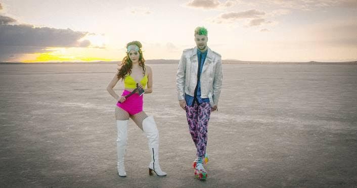 two people standing in the middle of an empty field with one person dressed up as a man and woman