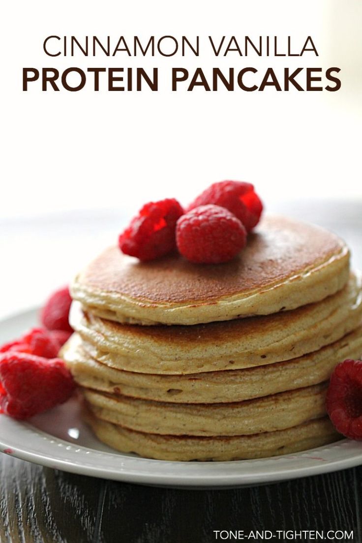 a stack of pancakes topped with raspberries on top of a white plate and text overlay reads cinnamon vanilla protein pancakes