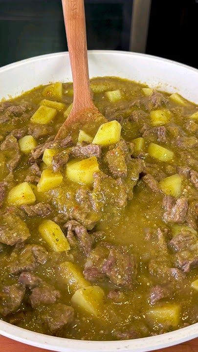 a white bowl filled with meat and potatoes