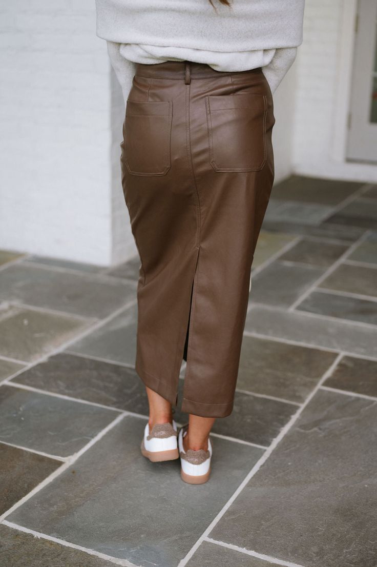 Expertly crafted with a high waistline, this brown faux leather midi skirt is both stylish and functional. Complete with pockets for added convenience, this skirt is the perfect addition to any wardrobe. Add a touch of sophistication to your outfit with this must-have piece! 100% polyurethane Model is 5'4" with a 25" waist and 38" hips and wearing a small. Size recs: 2-4 S 4-6 M 8-10 L Leather Midi Skirt For Work, Fall Pencil Skirt With Pockets, Relaxed Fit Pencil Skirt With Pockets For Fall, Relaxed Fall Pencil Skirt With Pockets, Fall Relaxed Pencil Skirt With Pockets, Chic Brown Midi Length Skirt, Fall Midi Pencil Skirt With Pockets, Fall Midi Skirt With Side Pockets, Brown Skirt For Fall