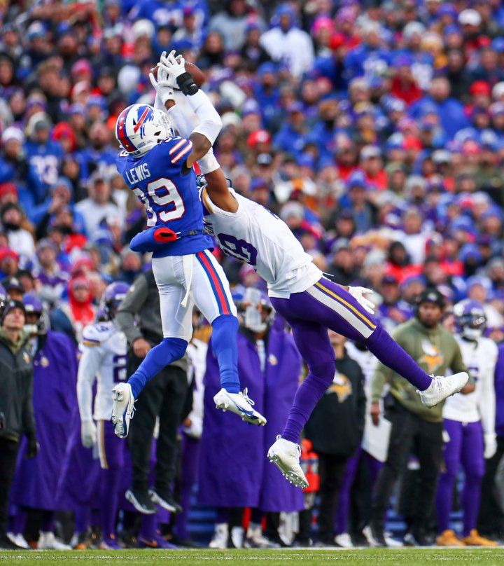 two football players jumping up in the air