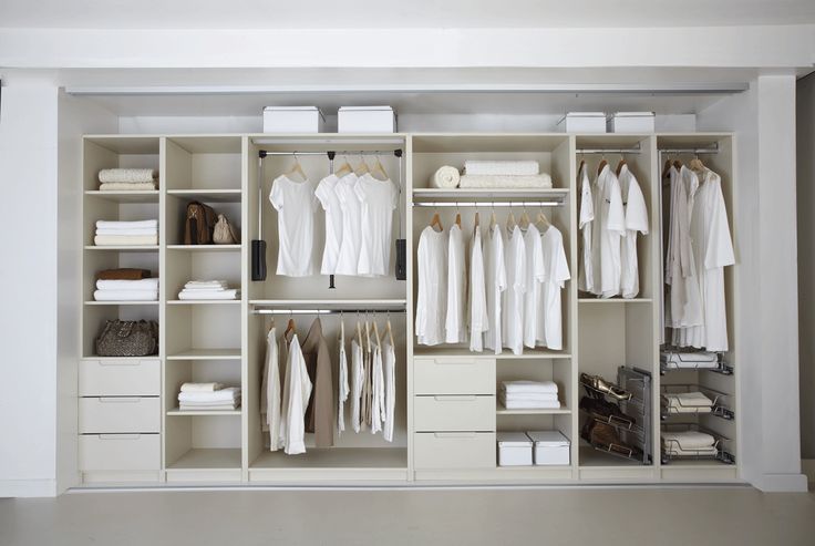 an organized closet with white clothes and linens