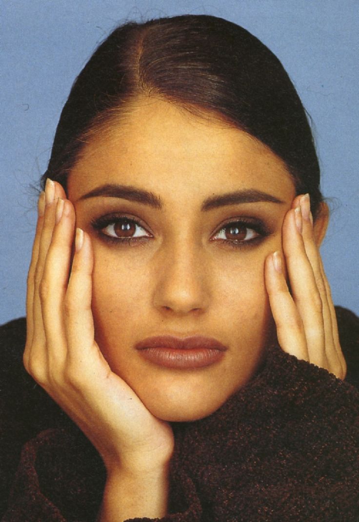 a woman with her hands on her head and eyes closed, posing for the camera