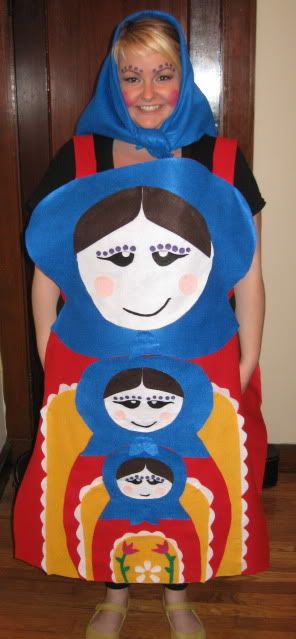 a woman in a costume made to look like matzoka dolls, standing next to a wooden door