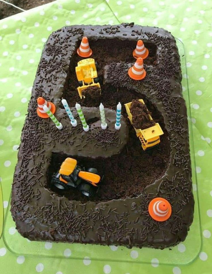 there is a chocolate cake with construction trucks on it