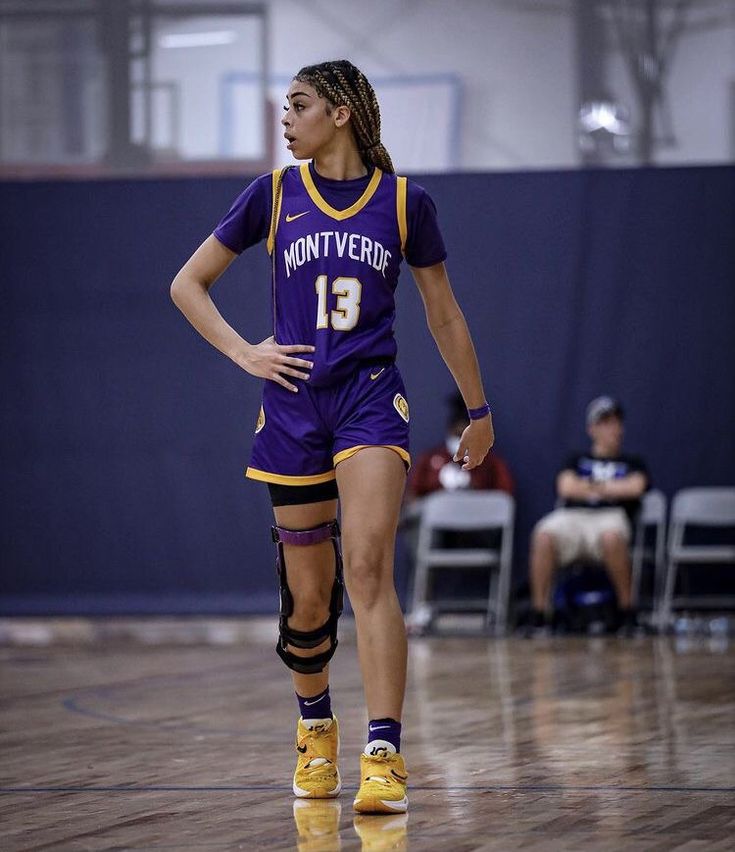 a female basketball player is standing on the court