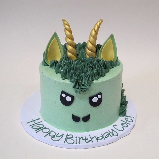 a birthday cake with green frosting and gold horns