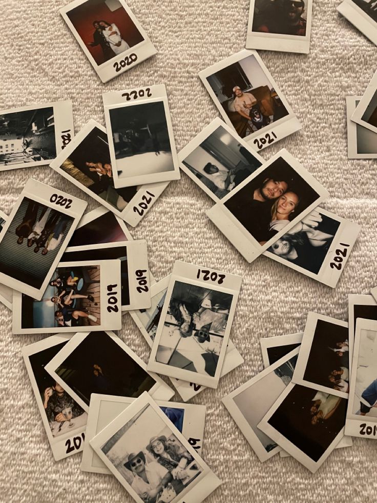 many polaroid photos are laying on the bed