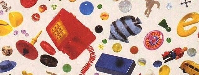 an assortment of toys and objects are scattered on a white surface, including a phone