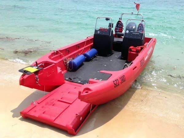 a red boat sitting on top of a sandy beach