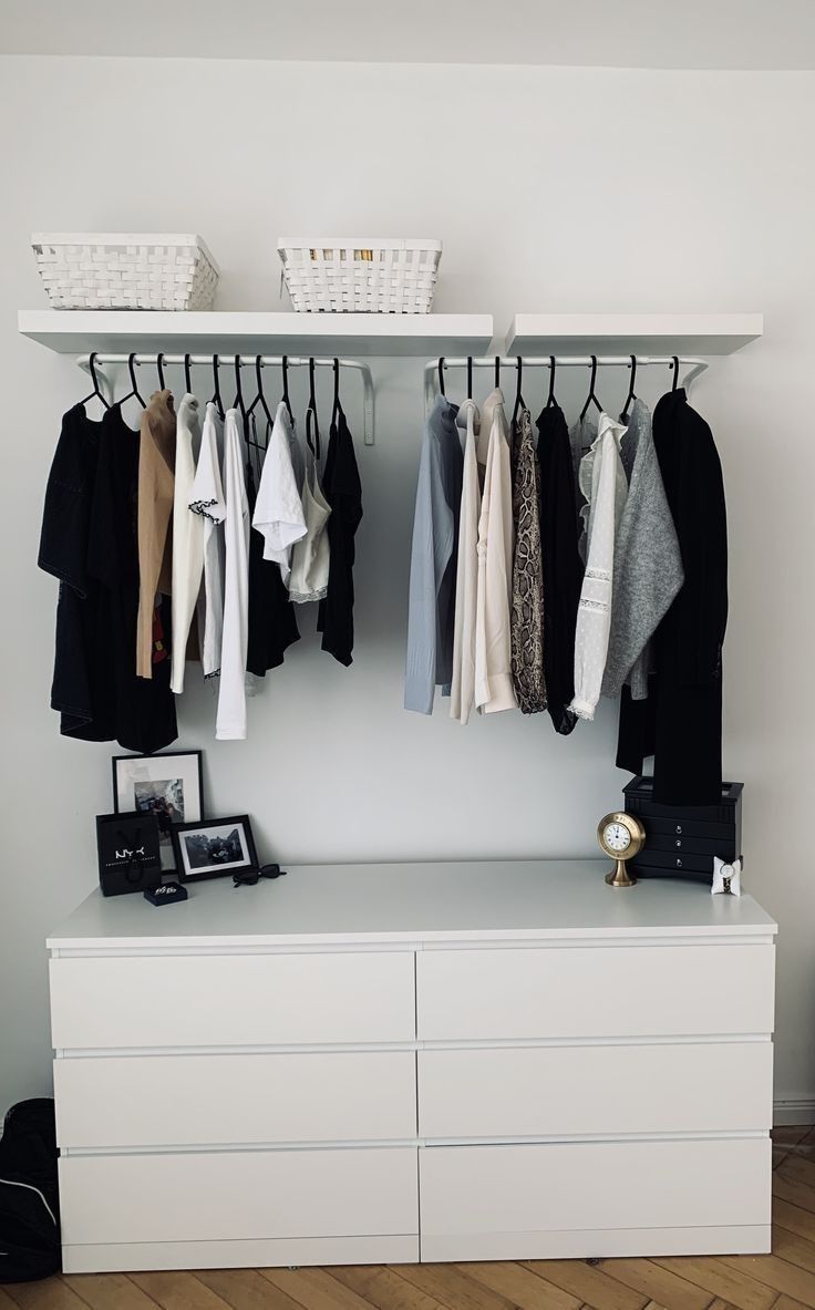 an organized closet with clothes hanging on rails