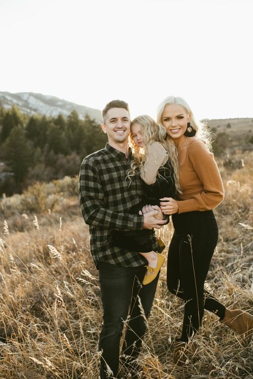 a man and woman standing in tall grass