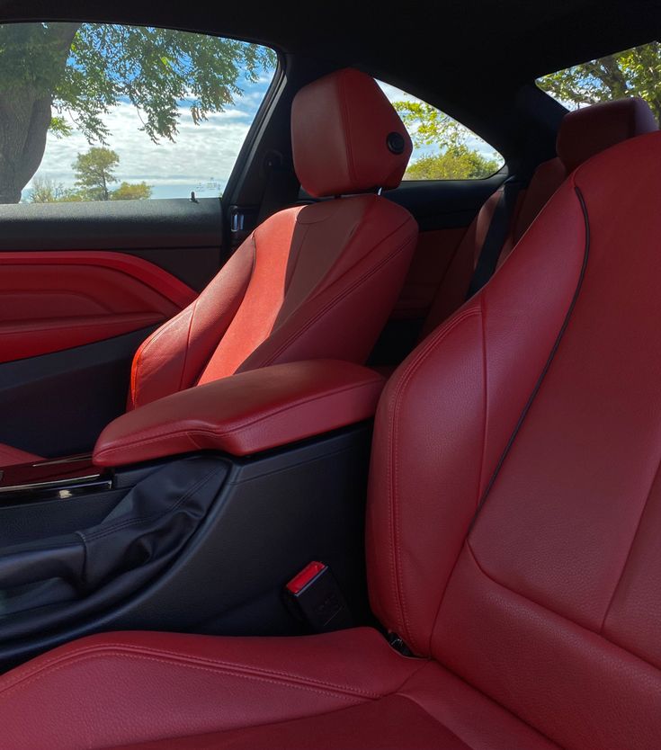 the interior of a car with red leather seats