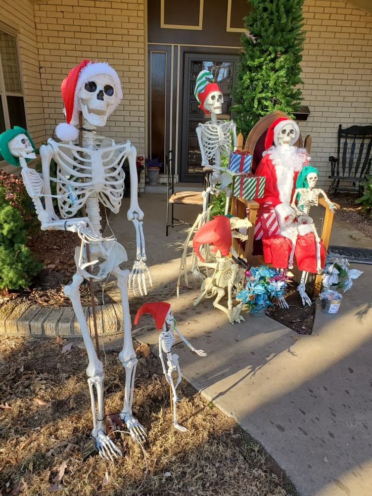 skeleton statues in front of a house decorated for christmas