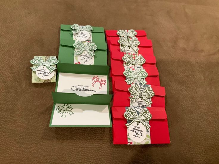 three red and green boxes with tags on them sitting on a brown surface next to each other