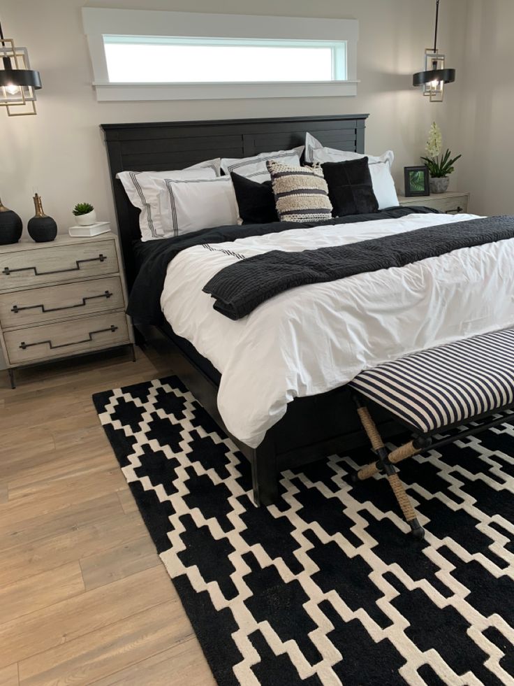 a large bed sitting on top of a black and white rug