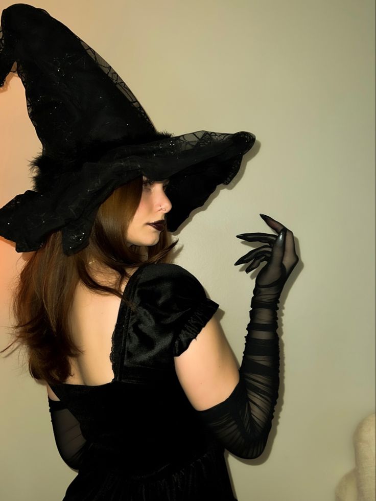 a woman in a black dress and witch hat