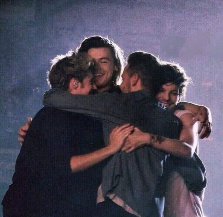 three young men hugging each other on stage