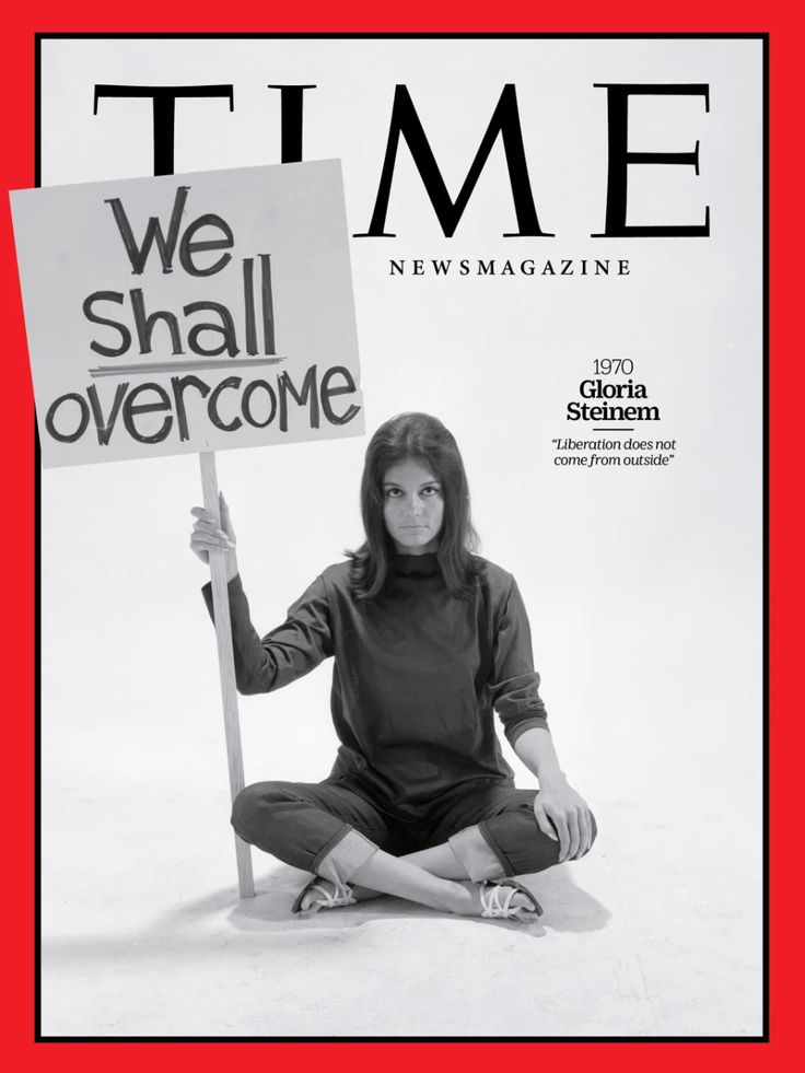 a woman sitting on the ground holding a sign that says we shall overcome in front of her