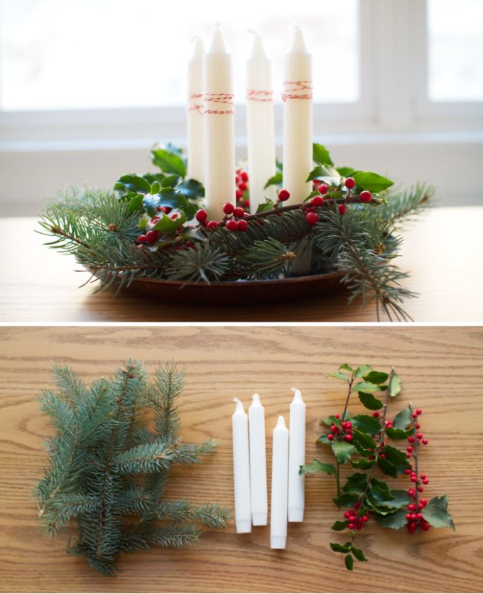 candles and greenery are arranged in a bowl