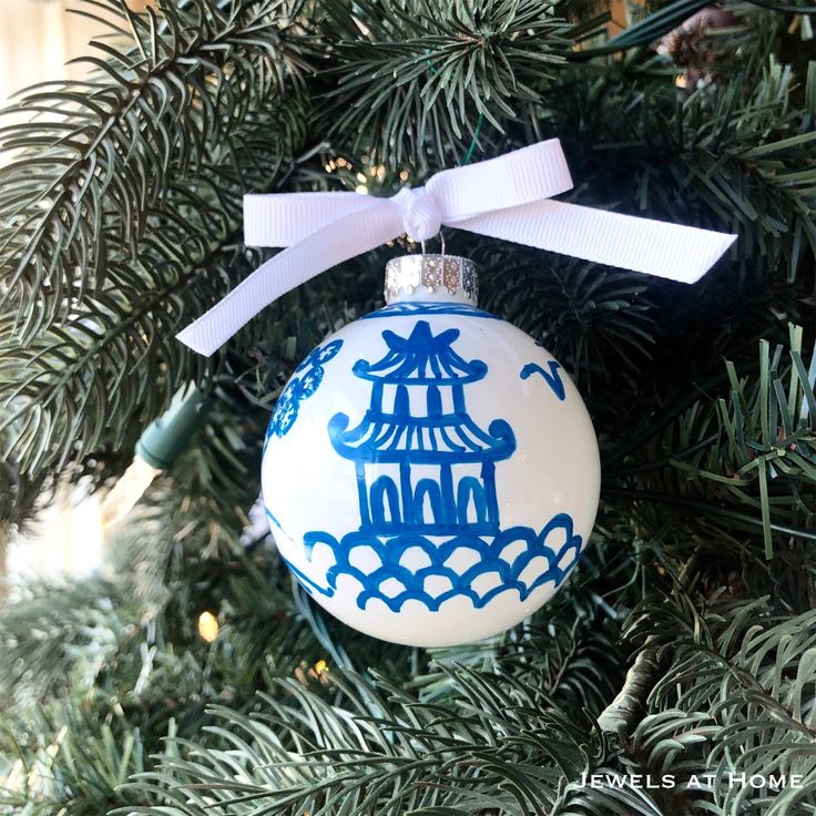 a blue and white ornament hanging from a christmas tree