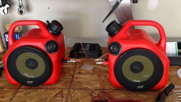 two red speakers sitting on top of a wooden table