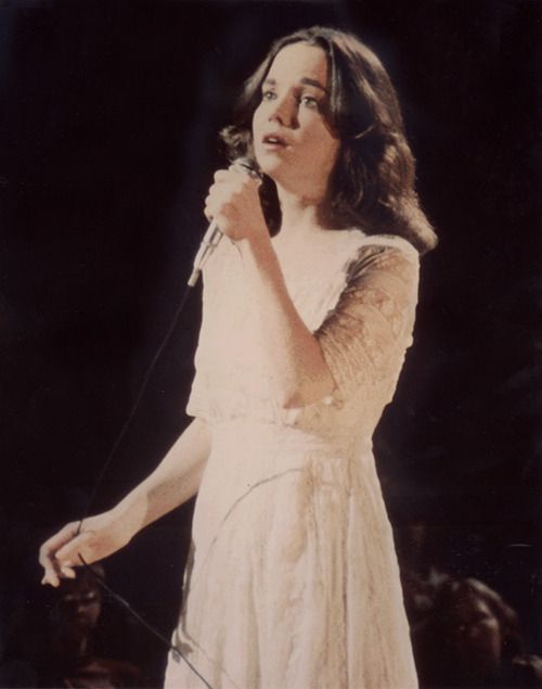 a woman in a white dress holding a microphone