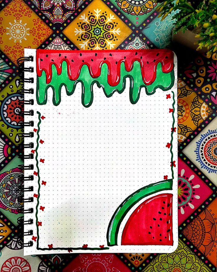 an open notebook with watermelon painted on the cover and decorative designs around it