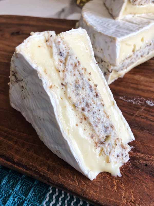 some kind of cheese sitting on top of a wooden cutting board