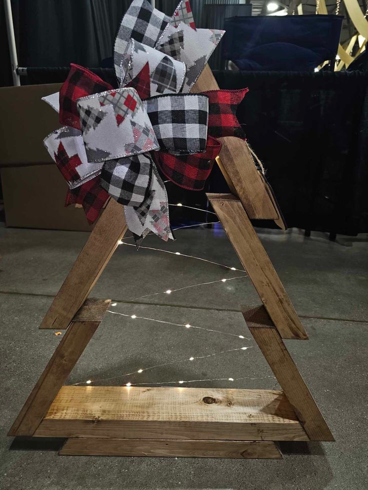 a wooden christmas tree with plaid bows on it