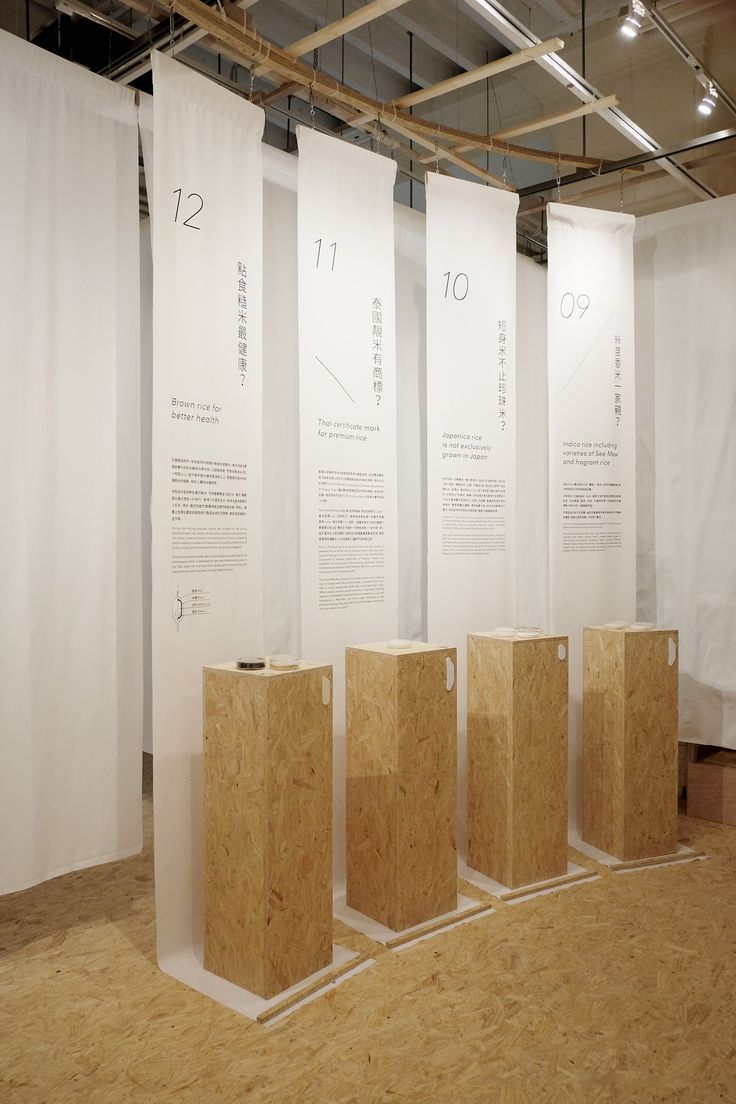 four wooden boxes sitting on top of a floor in front of white walls and drapes