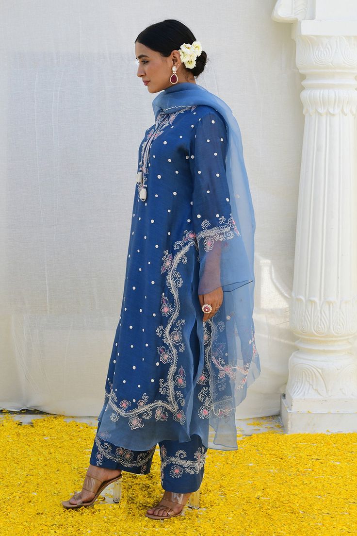 Jean blue kurta features an embroidered organza border on the slits, hemline as well as the sleeves, sprinkled with delicate dori dots all over. Paired with embroidered palazzo and an embroidered organza dupatta.
Components: 3
Pattern: Embroidered
Type Of Work: Floral,Polka Dot
Neckline: Notched
Sleeve Type: Bell Sleeves
Fabric: Banaras Silk Base
Color: Blue
Other Details: 
Front tie-up
Embroidered palazzo
Occasion: Mehendi and Haldi - Aza Fashions Elegant Blue Kurta For Traditional Ceremonies, Blue Silk Salwar Kameez With Intricate Embroidery, Blue Silk Sets With Intricate Embroidery, Blue Traditional Fitted Embroidered Fabric, Festive Blue Embroidered Fitted Fabric, Silk Blue Kurta With Intricate Embroidery, Blue Salwar Kameez With Intricate Embroidery, Blue Straight Kurta Set With Intricate Embroidery, Blue Embroidered Organza Dupatta