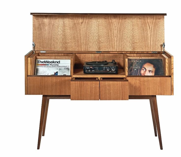 an old record player is sitting on a wooden cabinet with magazine and magazines in it