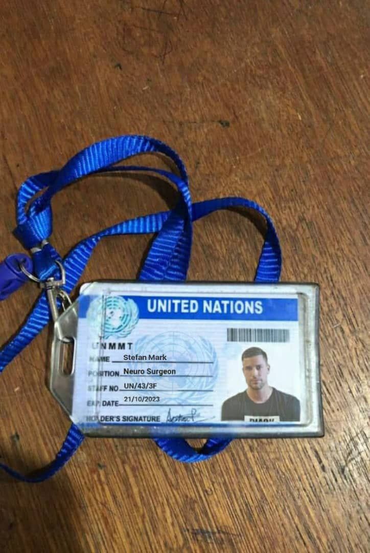 a id card is attached to a lanyard on a wooden table with a blue lanyard